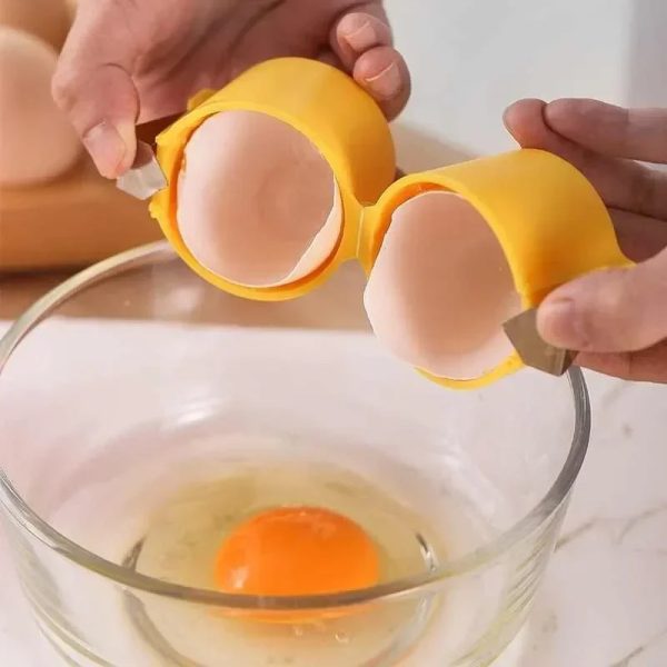 Hands splitting an egg over a bowl with a yellow egg separator